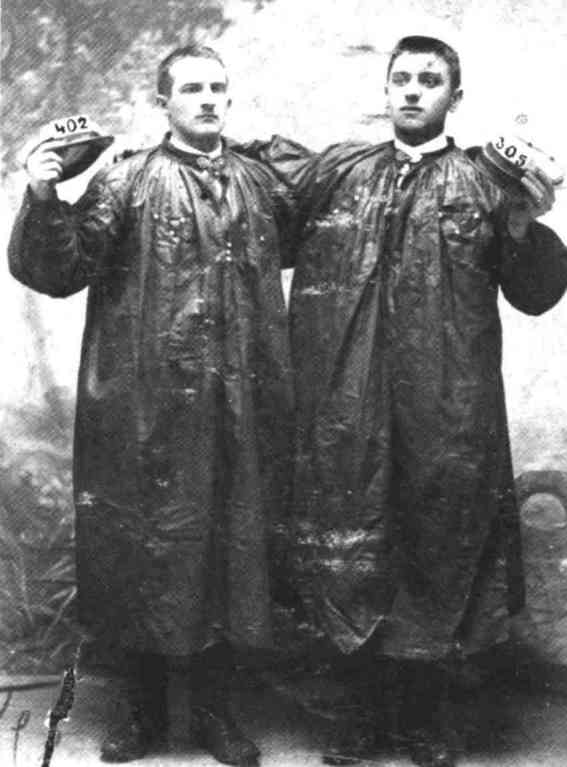 Cuesmes : Ces deux Cuesmois de 1907, portant sarrau et casquette blanche, viennent de participer au tirage au sort, qui avait lieu  Mons. A gauche, Lucien Delsaut, brandissant un numro plus lev, a tir " l' Cocarde".