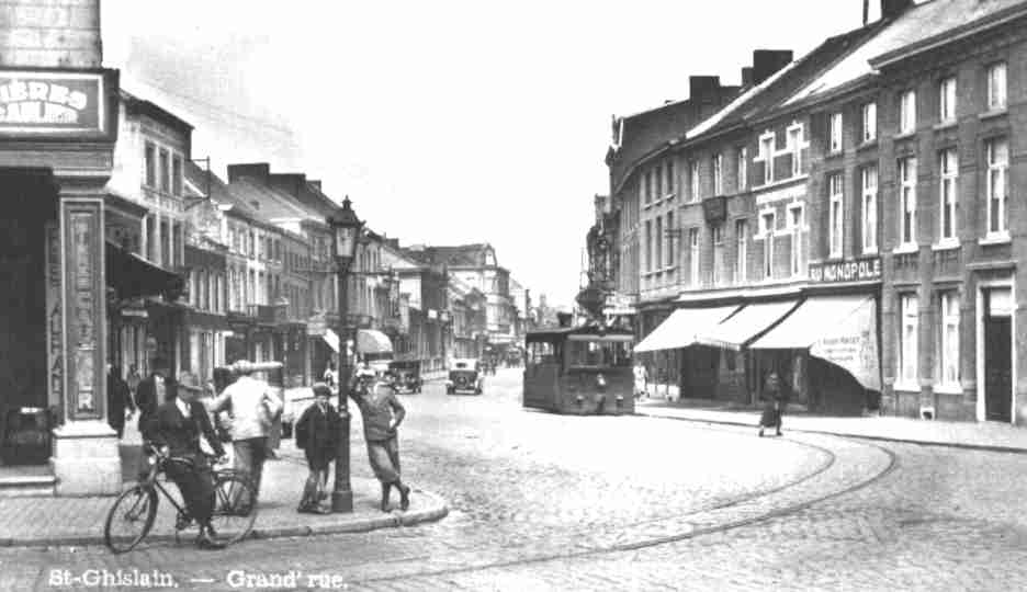 Saint-Ghislain : Entre de la Grand-Rue entre 1930 et 1935, date de remplacement du tram  vapeur par des autorails. A droite la maison de confection Au Monopole cre vers 1910 par Lopold Richil et son pouse Laure Mallet.