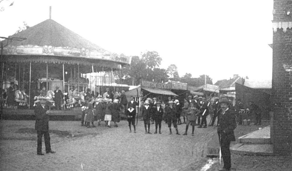 Hautrage : la place en 1920 lors d'une kermesse. On apercoit un "galopant"  vapeur surmont de sa chemine.