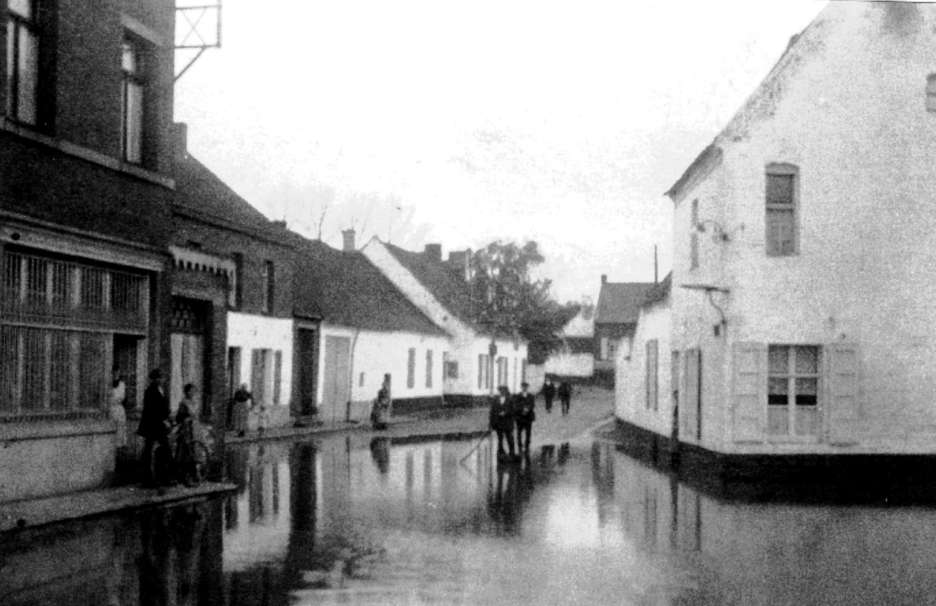Hautage : rue de la Couronne en 1920 innonde par le ruisseau des Trois Fontaines qui travaisait la place d' Hautrage  ciel ouvert.