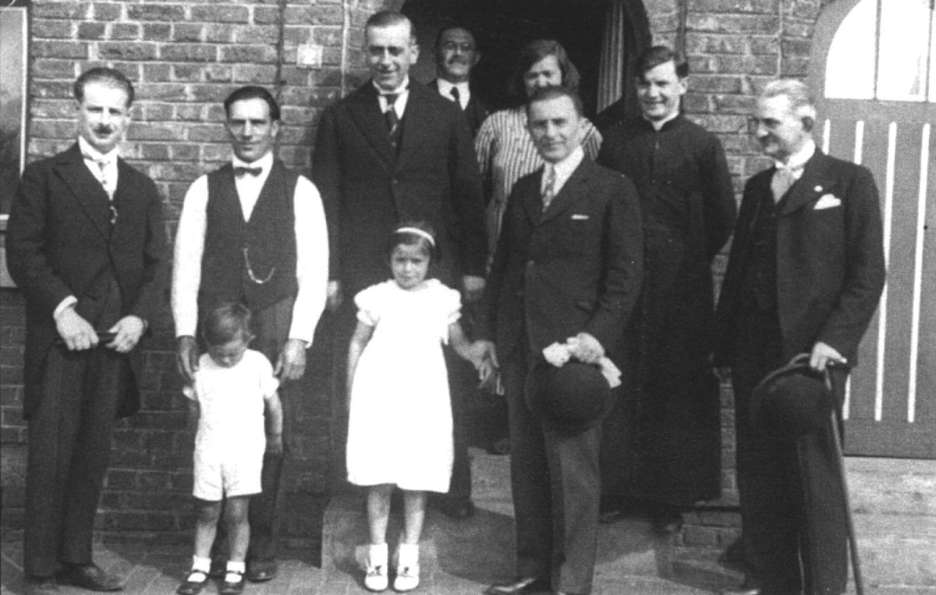 Hautrage : 1938, visite du consul et du vice-consul de Pologne des maisons du charbonnage situes rue de Varsovie. De gauche  droite : M. Culot (directeur du charbonnage), W. Oszczak et le petit Joseph, M. Moyence et la petite Ccile, au fond B. Budzynski et madame Oszczak-Budzynski, devant elle le consul, le cur Moskwa et le vice-consul.